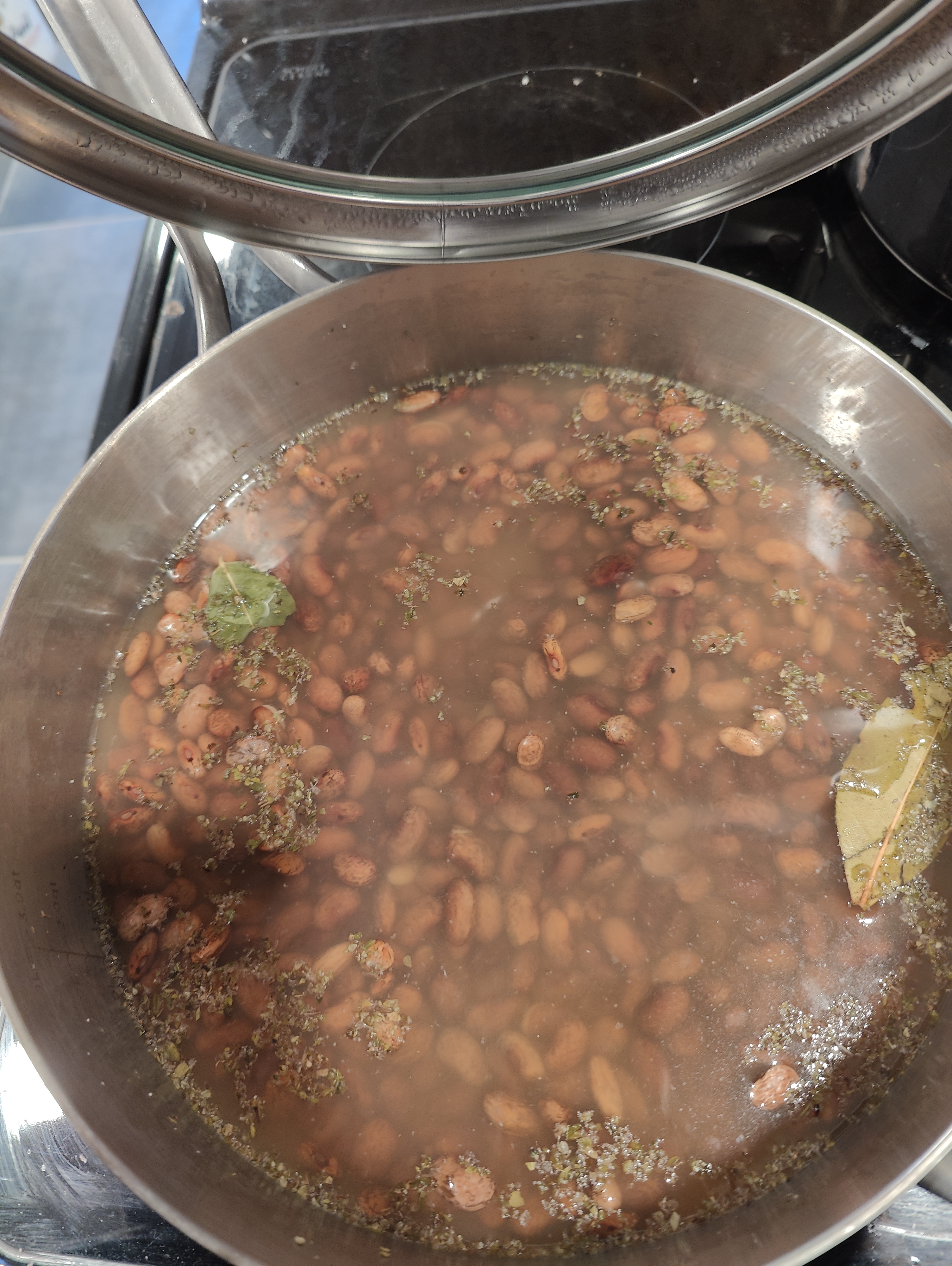 a pot of beans and spices begining to steam 