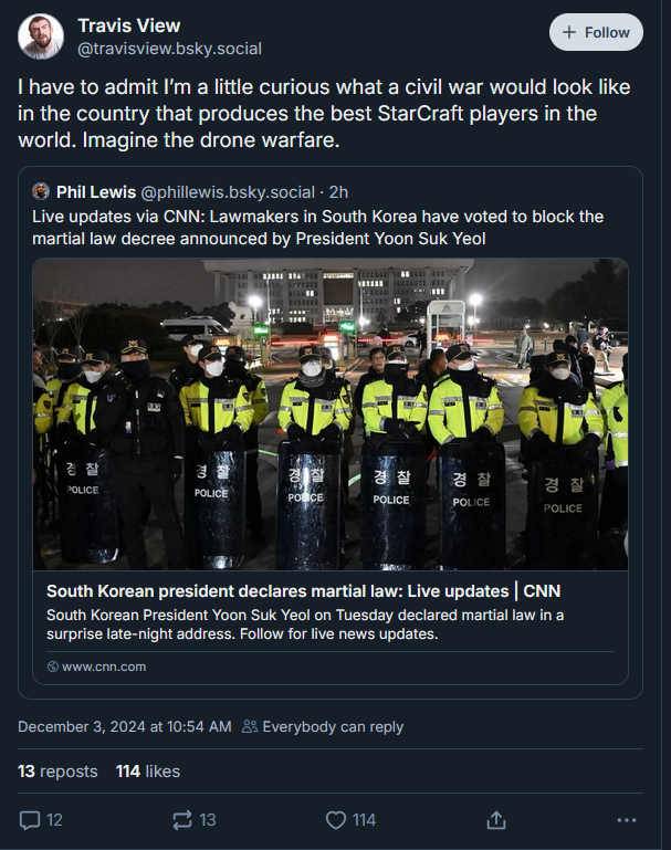 In a post from Bsky Travis View says "I have to admit I'm a little curious what a civil war would look like in a country that produces the best StarCraft players in teh world. Imagine the drone warfrare". Below Phil Lewis says "Live updates via CNN: Lawmakers in South Korea have voted to block the martial law decree anounced by President Yoon Suk Yeol". Below that a picture of SK riot police standing with shields wearing yellow hi-vis jackets in front of a Worst Korea governjment building. Further texts re-state's Phil Lewis' comment