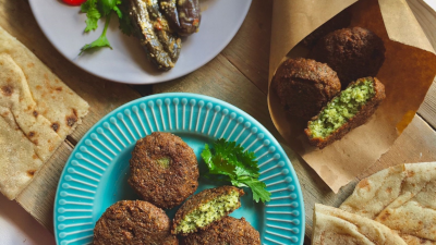 A couple plates of Egyptian Falafel, they are green on the inside and crispy brown on the outside