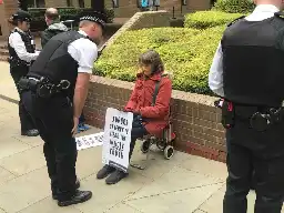 Police just arrested 11 people on the orders of a judge for HOLDING SIGNS OUTSIDE A COURT