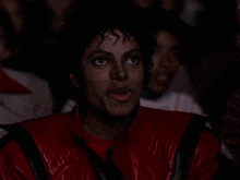 gif animado do Michael Jackson no cinema comendo pipoca enquanto assiste a algum filme.