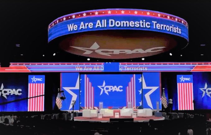 CPAC stage with a "We are all domestic terrorists" banner over it. (Not photoshopped)
