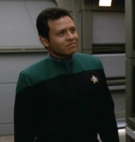 screenshot of King Abdullah II bin al-Hussein's appearance as an extra on Star Trek Voyager. He is wearing a Starfleet uniform and has a perplexed or skeptical facial expression.