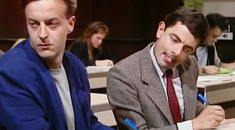 screenshot of Mr. Bean (Rowan Atkinson) copying answers to a test from the person sitting next to him