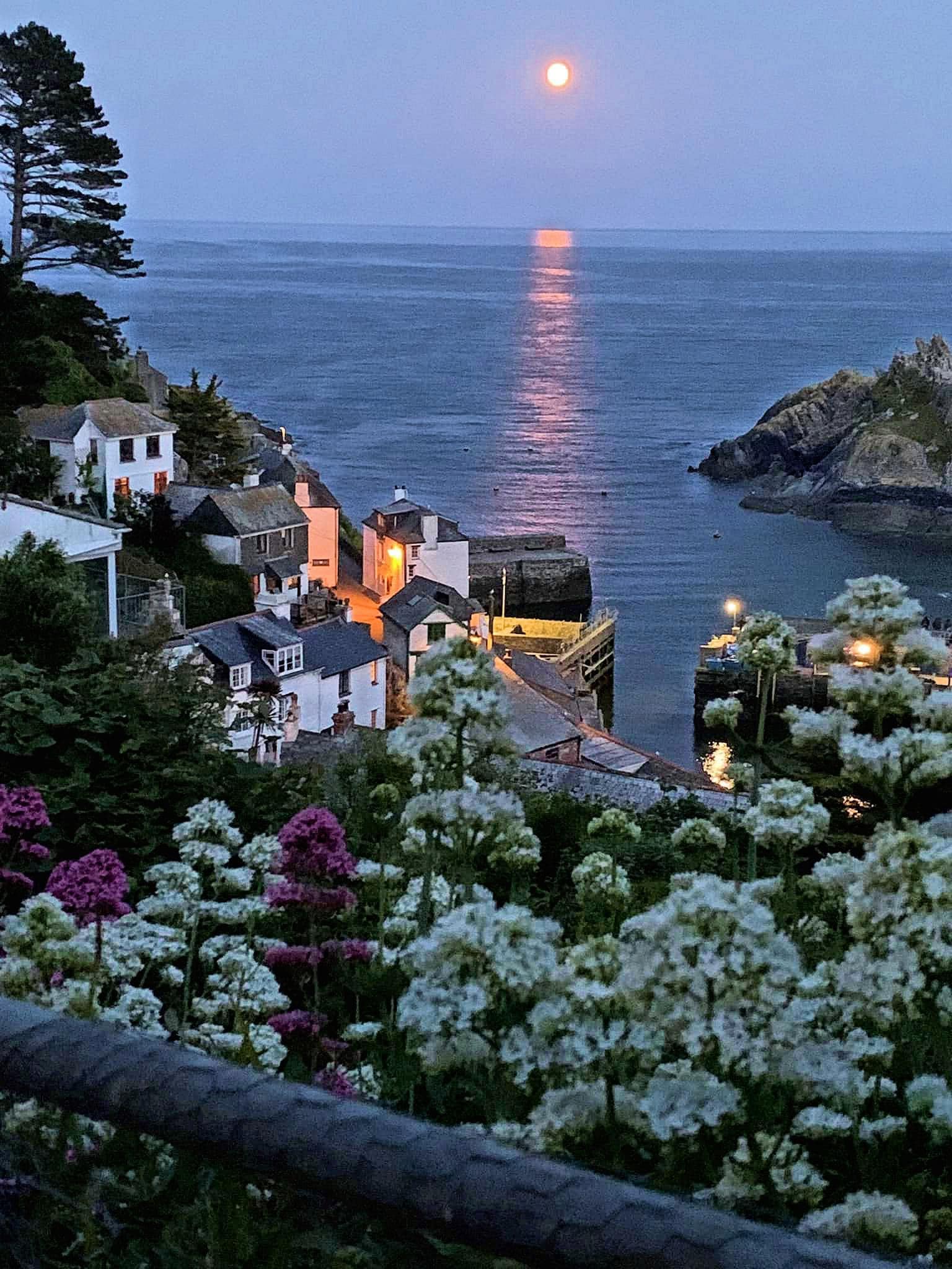 Moon over the English Channel seen from the fishing village of Polperro, Cornwall, England