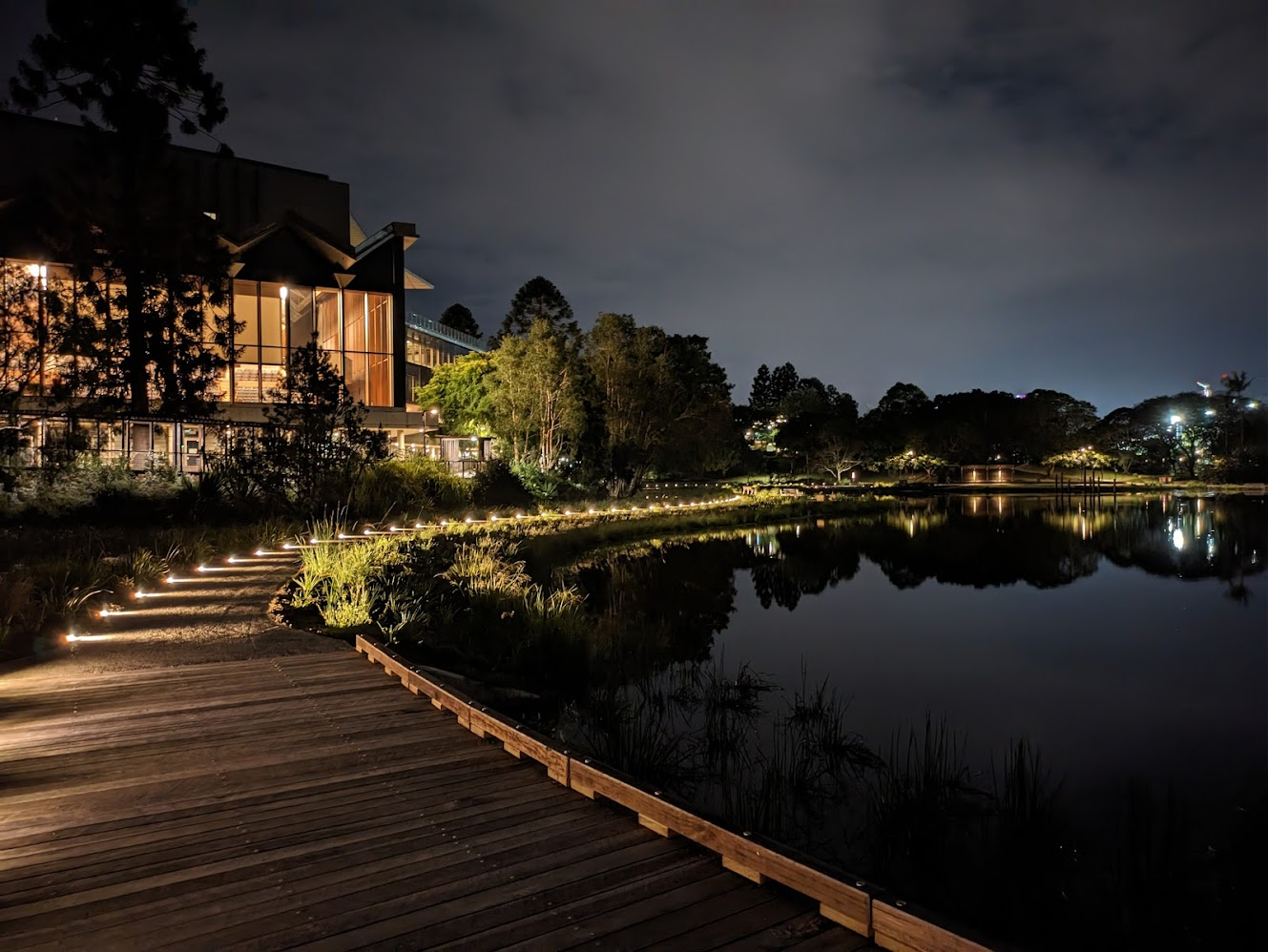 Photo of a pathway across a lake at night